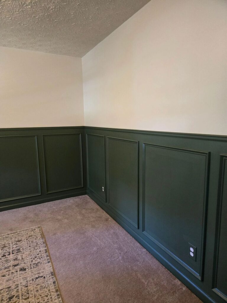 Bedroom with dark green board-and-batten wall moulding