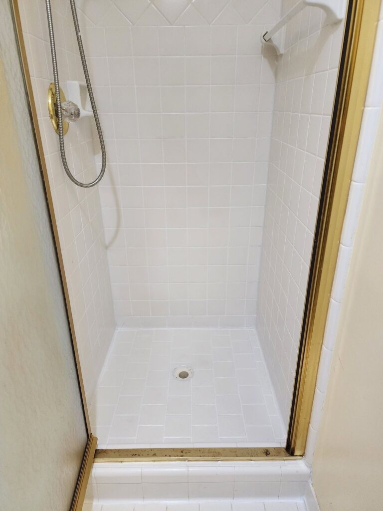 Tan tile shower after cleaning and sealing, grout looks uniform and new