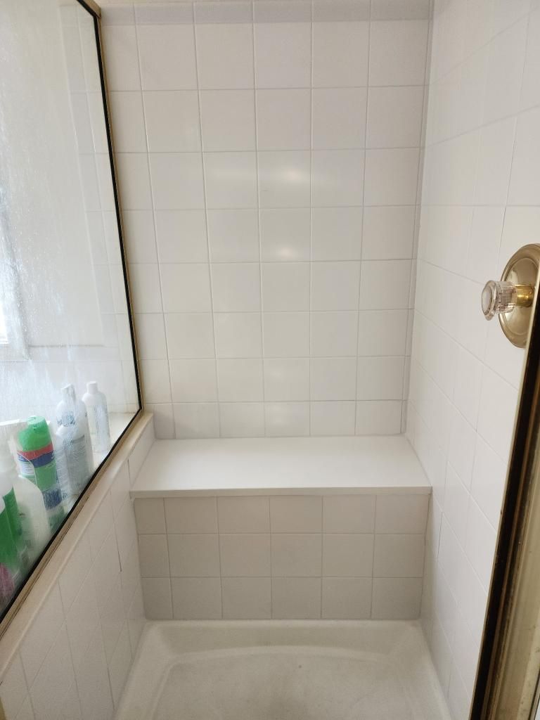 New engineered stone shower bench with reattached tiles and sealed grout