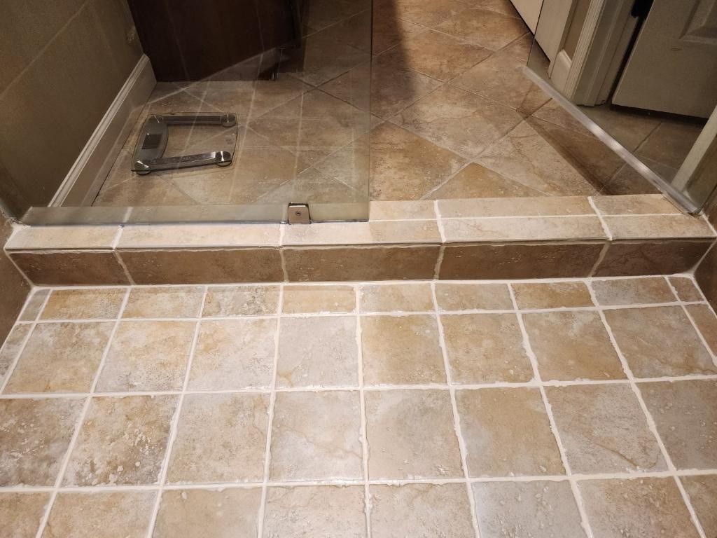 Repaired shower curb with new backerboard, reset tile and sealed grout